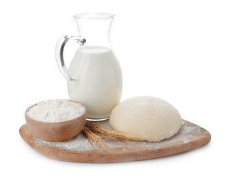 Board with dough, milk and flour on white background. Cooking pastries