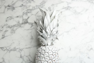 Photo of White pineapple on marble background, top view. Creative concept