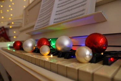 Festive decor on piano keys indoors, closeup. Christmas music
