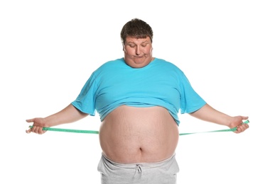 Emotional overweight man with measuring tape on white background