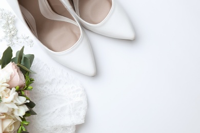 Pair of wedding high heel shoes on white background, top view