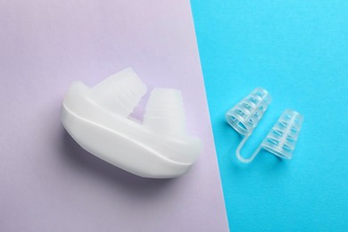 Different anti-snoring devices for nose on color background, flat lay