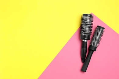 Round hair brushes on color background, flat lay. Space for text