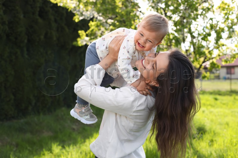 Photo of Happy mother playing with her cute baby in park on sunny day