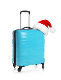 Stylish suitcase with Santa Claus hat isolated on white. Christmas vacation 