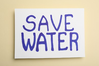 Photo of Card with words Save Water on beige background, top view