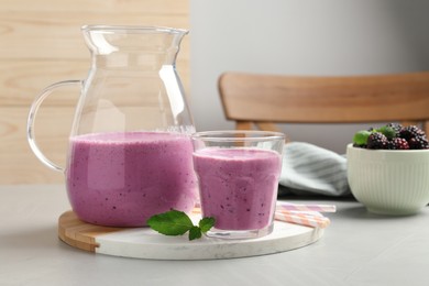 Delicious blackberry smoothie and mint on white table indoors, space for text