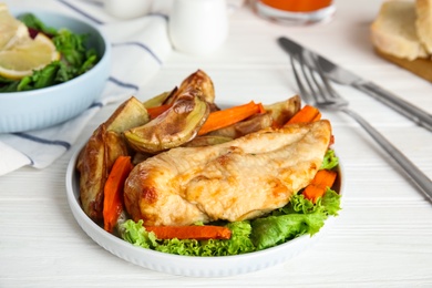 Photo of Delicious cooked chicken and vegetables on white wooden table, closeup. Healthy meals from air fryer