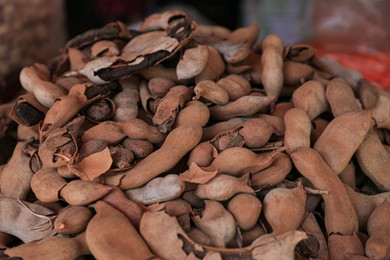 Heap of delicious tamarinds on counter at market, closeup