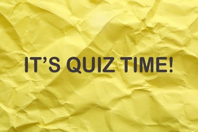Phrase IT'S QUIZ TIME on crumpled yellow paper 