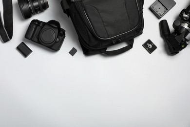 Professional photography equipment and backpack on grey background, flat lay. Space for text