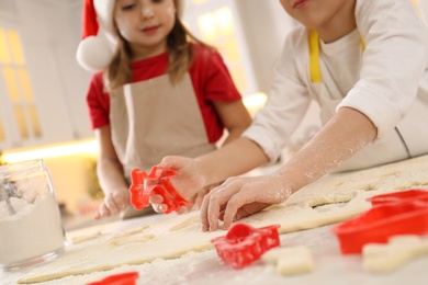 Little boy with his sister making Christmas cookies in kitchen, closeup