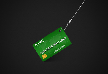 Hook with credit card on black background. Cyber crime