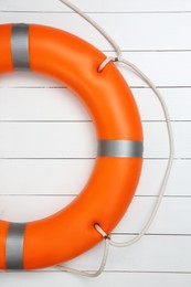 Orange lifebuoy on white wooden background. Rescue equipment