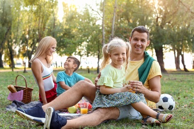 Happy family having picnic in park on sunny day