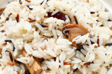 Delicious rice pilaf with mushrooms as background, closeup