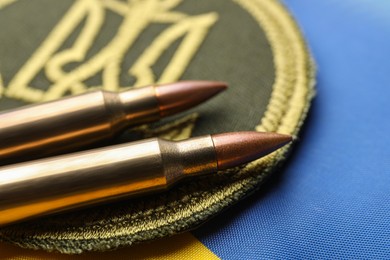 Bullets and military patch on Ukrainian flag, closeup