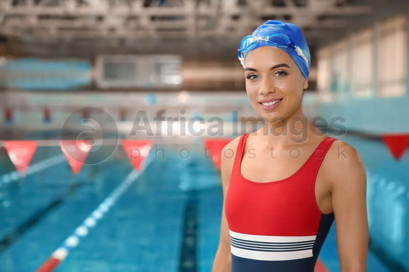 Young athletic woman standing near swimming pool
