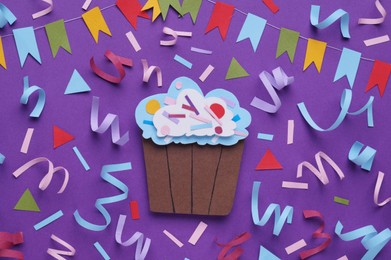 Photo of Birthday party. Paper cupcake and confetti on purple background, flat lay