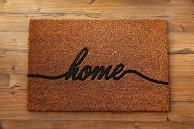 Photo of Doormat with word Home on parquet floor, top view