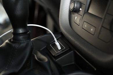 White USB charging cable plugged in inside modern car