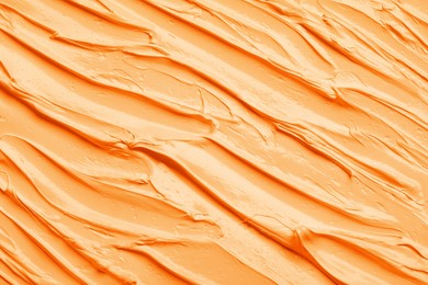 Strokes of pale orange oil paint as background, closeup