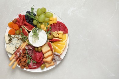 Set of different delicious appetizers served on light grey table, top view. Space for text