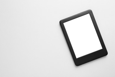 Modern e-book reader with blank screen on white background, top view. Space for text
