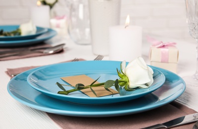 Elegant festive table setting with blank card in restaurant