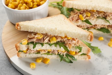 Photo of Delicious sandwiches with tuna, corn and greens on light grey table