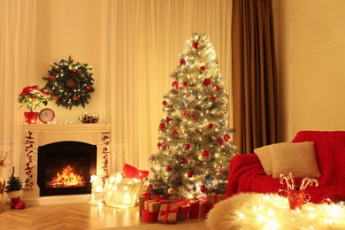 Beautiful living room interior with burning fireplace and Christmas tree in evening