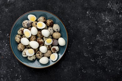 Photo of Peeled and unpeeled hard boiled quail eggs in plate on black table, top view. Space for text