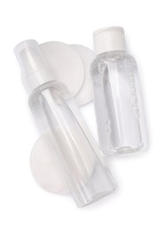 Bottles with micellar cleansing water and cotton pads on white background, top view