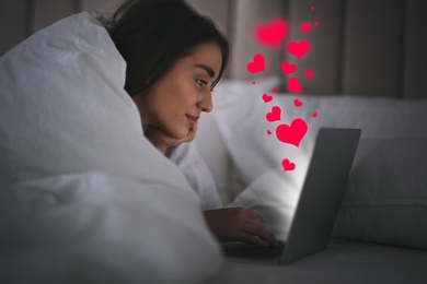 Young woman visiting dating site via laptop indoors