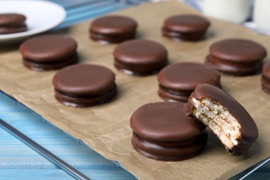 Tasty choco pies on light blue wooden table