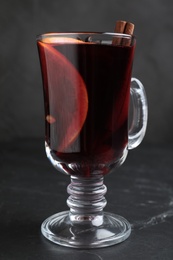 Aromatic mulled wine on black table, closeup