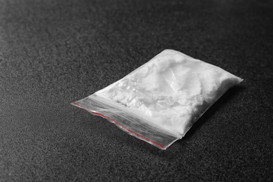 Cocaine in plastic bag on black background