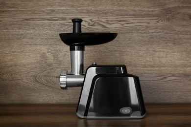 Photo of Modern electric meat grinder on wooden table
