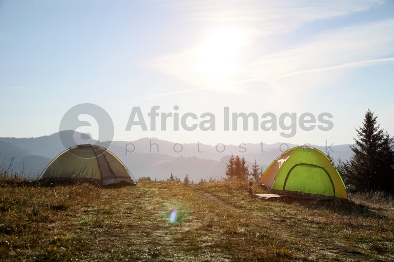 Beautiful camping tents in mountains on sunny day