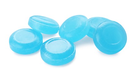 Many light blue cough drops on white background