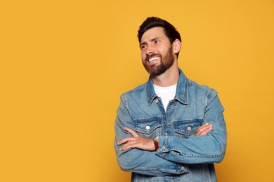 Portrait of smiling bearded man on orange background. Space for text