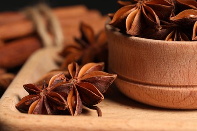 Aromatic anise stars on wooden board, closeup