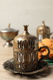 Photo of Tea and baklava dessert served in vintage tea set on wooden table, closeup
