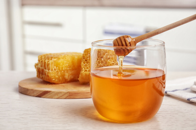 Glass jar of honey on white wooden table