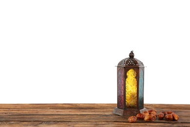 Muslim lamp and dates on wooden table against white background. Space for text