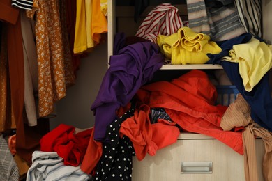 Photo of Messy wardrobe with different clothes. Fast fashion concept