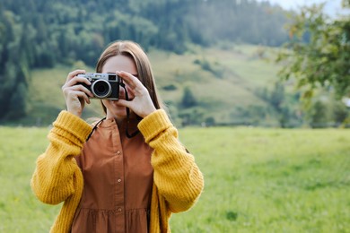 Photo of Woman taking photo with camera in mountains