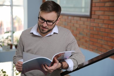 Young business man reading sports magazine at home