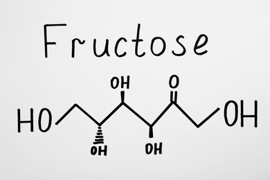 Photo of Word Fructose with drawn scheme on paper, top view