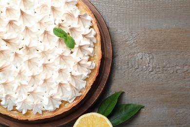 Delicious lemon meringue pie on wooden table, flat lay. Space for text